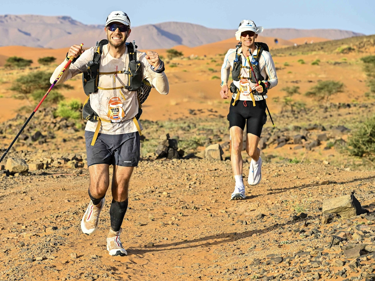 Twee lopers rennen samen door de Sahara tijdens de Marathon des Sables