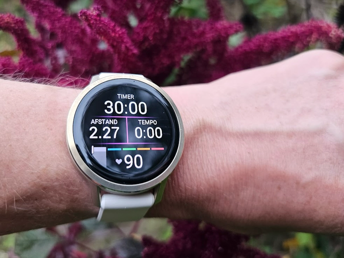 Garmin Venu 4 sporthorloge om de pols van een actieve vrouw buiten tijdens fietsen