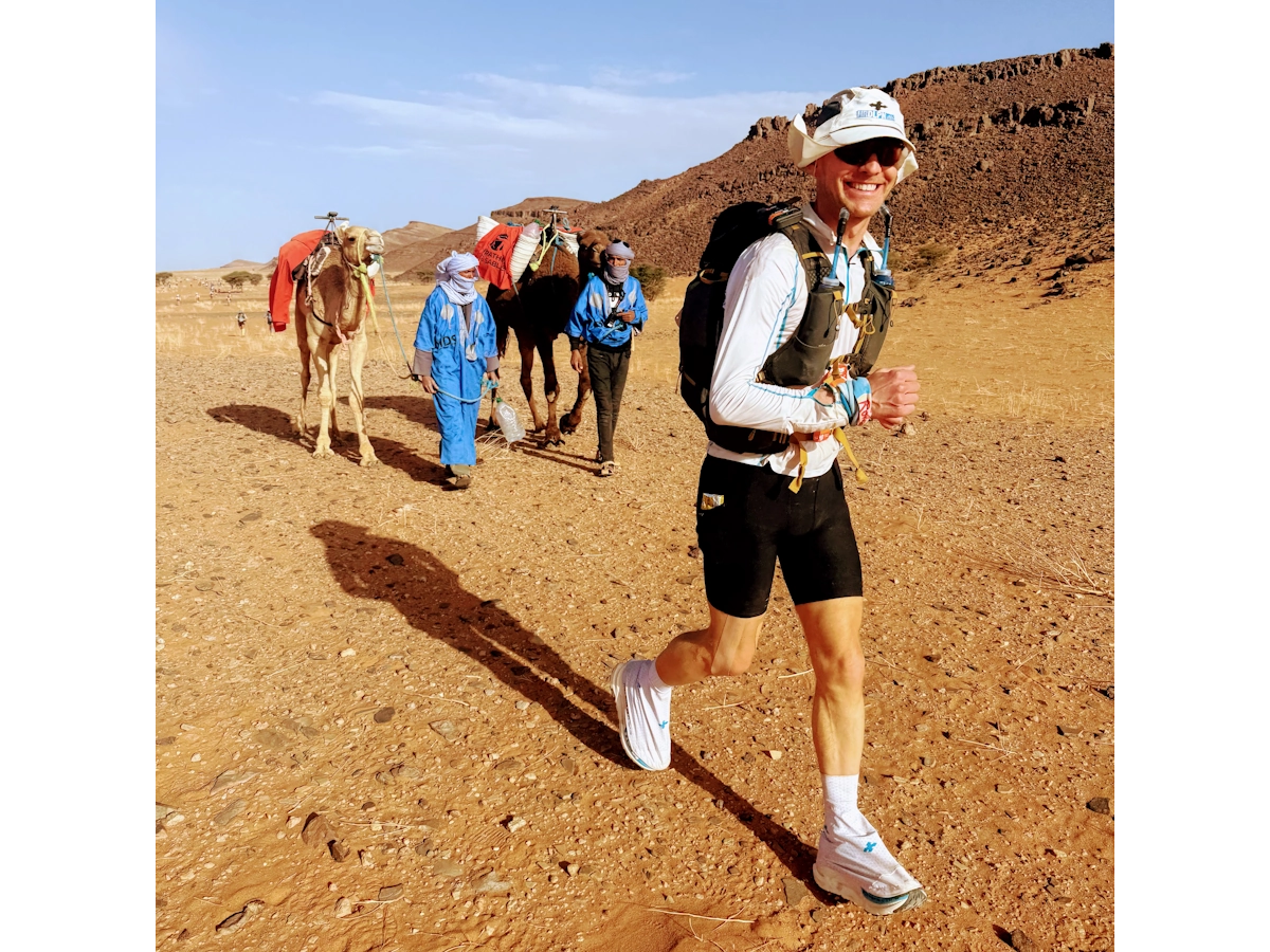Kamelen langs route Marathon des Sables met loper