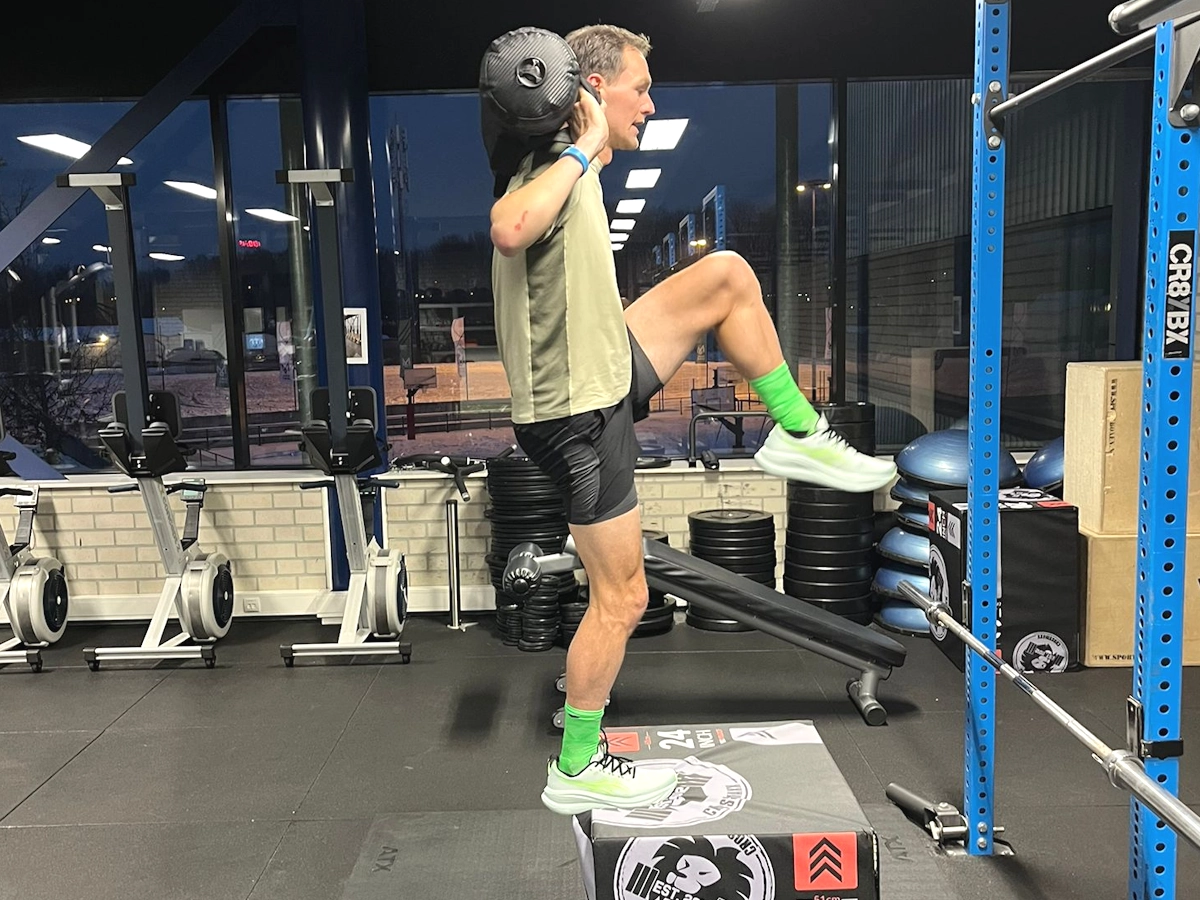 Peter doet krachttraining met een gewicht in de sportschool in nieuwe sportkleding