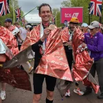 Peter die London Marathon medaille omhoog houd