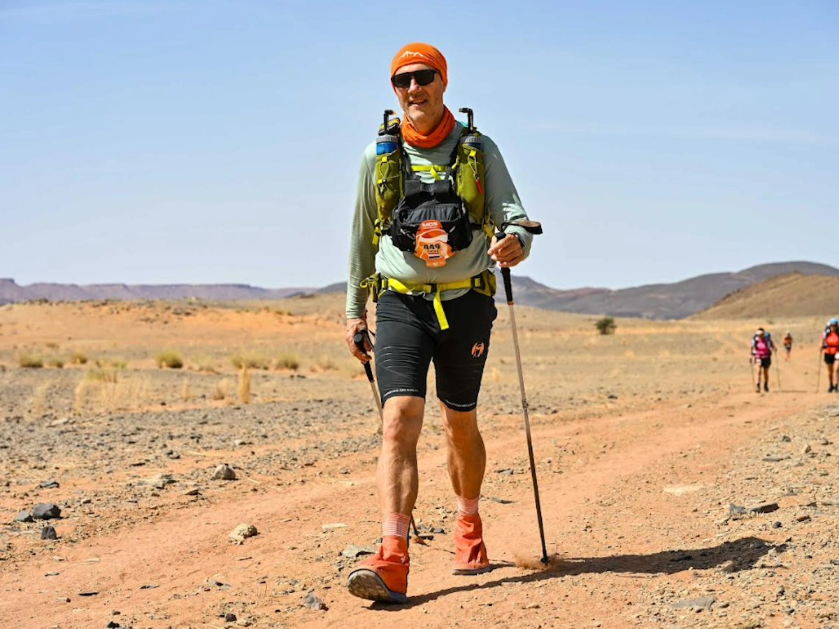 Evert tijdens een extreme wandeltocht door de woestijn met rugzak en zandduinen