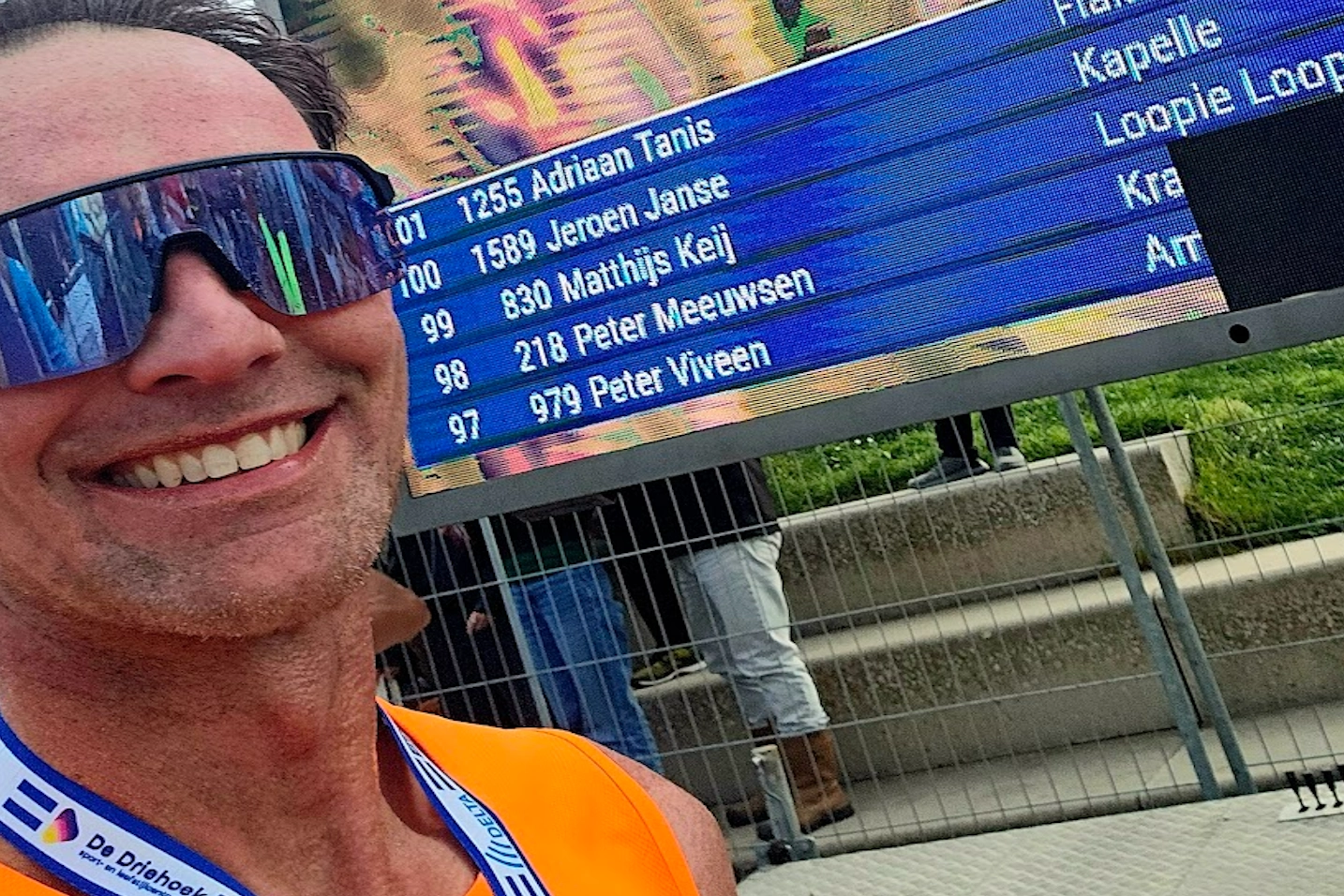 Blij moment bij de finishvlaggen na een zware stormloop tijdens de Kustmarathon Zeeland