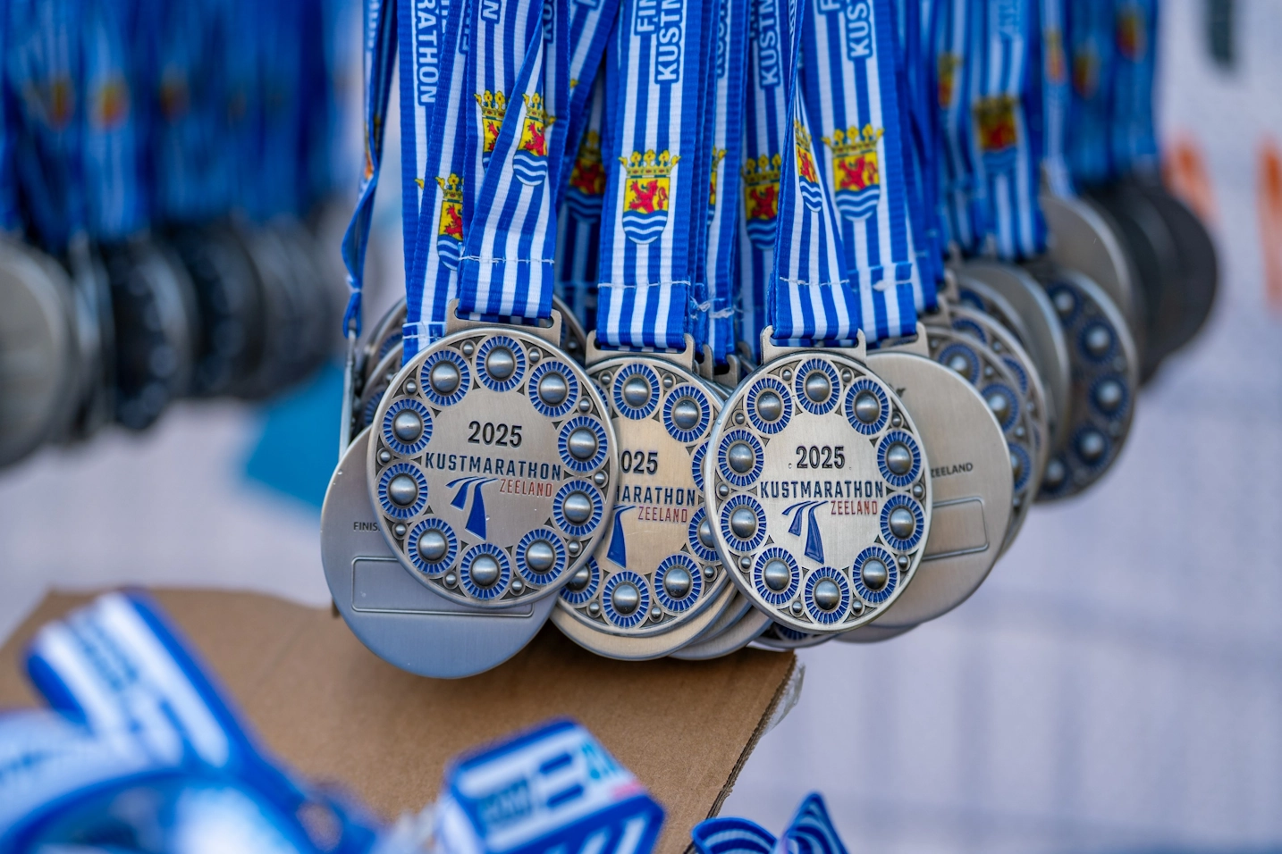 Medailles van de Kustmarathon Zeeland na het hardlopen met storm en windkracht 7