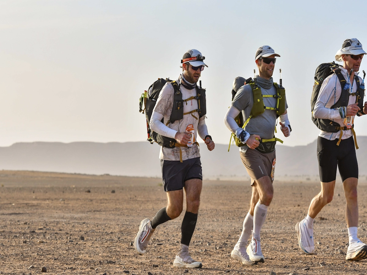 Teamgenoten rennen samen door het woestijnlandschap van de Marathon des Sables